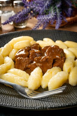 Soslu sığır eti yahnisi, patates köftesiyle servis edilir..