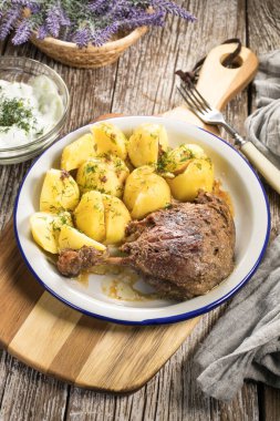 Patates ve salatalık ile servis edilen kızarmış ördek bacağı. Seçici odak.
