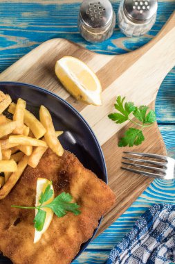 Tabağında patates kızartması olan kızarmış morina balığı..