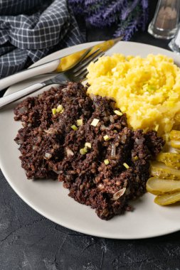 Kızarmış puding, patates püresi ve salatalık turşusu..