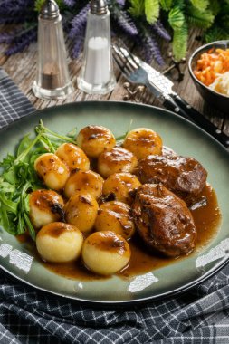 Geleneksel Alman haşlanmış domuz yanakları kahverengi soslu ve mantarlı Silezya köftesi ile servis ediliyor..