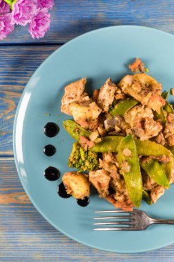 Mavi tabakta kızarmış tavuk ve sebze..