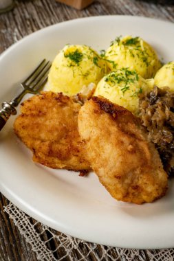 Kızarmış morina filetosu, haşlanmış patates ve mantarlı kızarmış lahana turşusu..