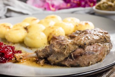 Kızarmış ördek bacağı, patates köftesi ve kızılcık..