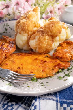 Haşlanmış karnabaharla servis edilen marine edilmiş tavuk göğsü..