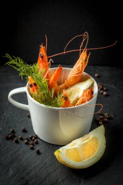 Taş plaka üzerinde kupada karides. Seçici odak. Karanlık ışık.