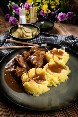 Sos ve patates püresiyle servis edilen haşlanmış hindi eti. Sığ alan derinliği. 