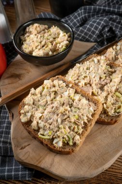 Tahta bir tahtanın üzerinde ton balıklı sandviç ve yumurta. Sığ alan derinliği. 