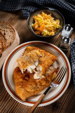 Lahana turşulu ve havuçlu kızarmış morina filetosu. Sığ alan derinliği. 