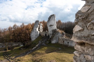 OGRODZIENIEC, POLAND - 27 Şubat 2022: Tarihi binayı ziyaret eden turistlerle birlikte Ogrodzieniec şatosunun kalıntıları.