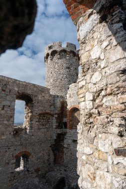 OGRODZIENIEC, POLAND - 27 Şubat 2022: Tarihi binayı ziyaret eden turistlerle birlikte Ogrodzieniec şatosunun kalıntıları.