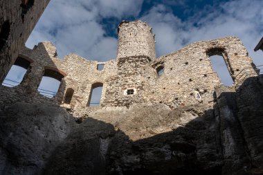 OGRODZIENIEC, POLAND - 27 Şubat 2022: Tarihi binayı ziyaret eden turistlerle birlikte Ogrodzieniec şatosunun kalıntıları.