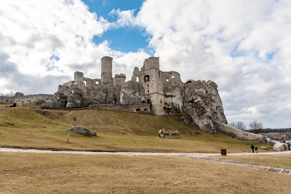 OGRODZIENIEC, POLAND - 27 Şubat 2022: Tarihi binayı ziyaret eden turistlerle birlikte Ogrodzieniec şatosunun kalıntıları.