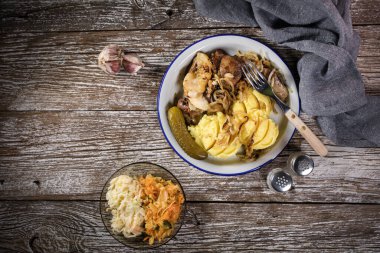 Kızarmış ciğer, soğan ve elma haşlanmış patates ve salatalık turşusu ile servis edilir. Üst görünüm.