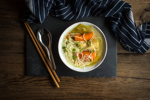 Tasty home broth with vegetables and noodles.