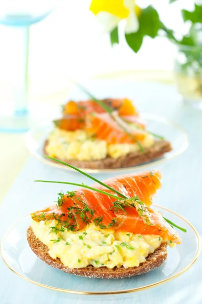 Toast with scrambled eggs,salmon and chives — Stock Photo, Image