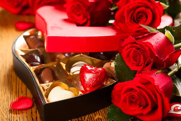 Box of chocolate truffles with red roses Royalty Free Stock Photos