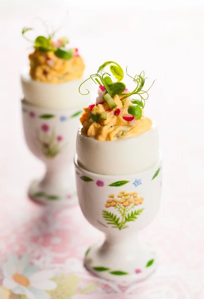 Stuffed eggs in egg cups — Stock Photo, Image