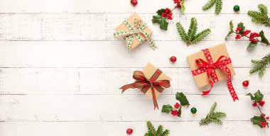 Noel arkaplanı hediye kutuları, Noel süslemeleri ve beyaz ahşap arka planda köknar dalları. Kış festivali konsepti. Düz yat, boşluğu kopyala.