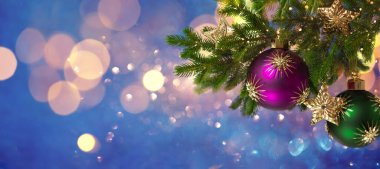Noel süsleri ve yeni yıl dekorasyonu. Noel baloları, köknar dallarındaki altın yıldızlar şenlikli bokeh arka planda. Kış tatili tebrik kartı..