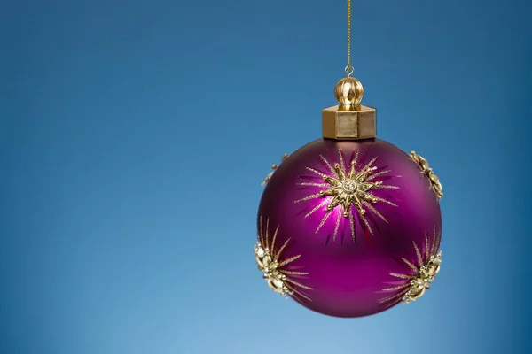 Bola Púrpura Navidad Con Estrellas Doradas Sobre Fondo Azul Festivo — Foto de Stock