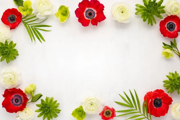 花枠構成 赤アネモネ 白ランヌクルス 熱帯の花 緑多肉植物の配置と光の背景に葉 トップビュー コピースペース — ストック写真
