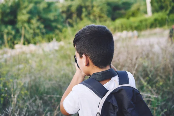 Young Child Taking Photos in the street.