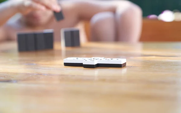 A family playing domino game in a wooden table.