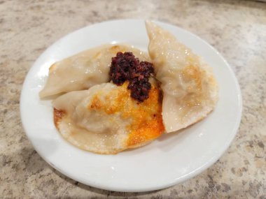 Tabakta kırmızı biber soslu Çin usulü hamur köftesi.