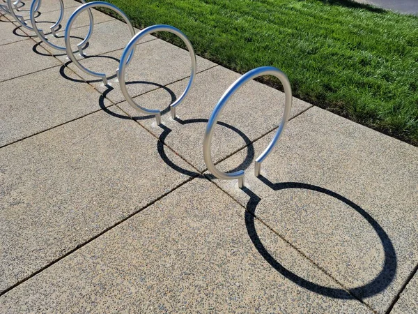 Portabici circolare in metallo con ombre curve su cemento — Foto Stock