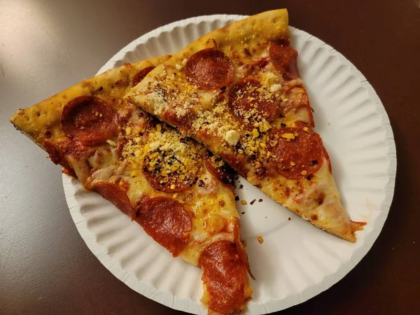 Plátky feferonky a sýrové pizzy na papírovém talíři — Stock fotografie