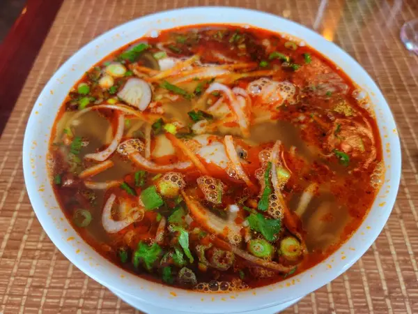 Pikantní vietnamská hovězí polévka v misce na stole — Stock fotografie