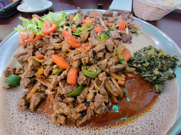 Comida etíope injera pão com bife e tomate — Fotografia de Stock