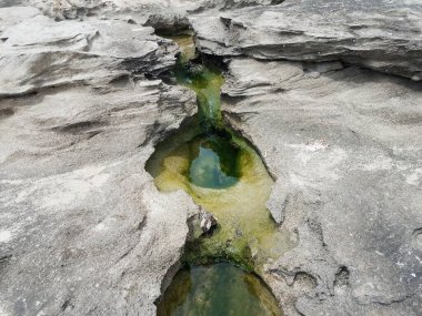 Porto Riko 'da kumsalda gri kaya ya da taş delikleri ve su