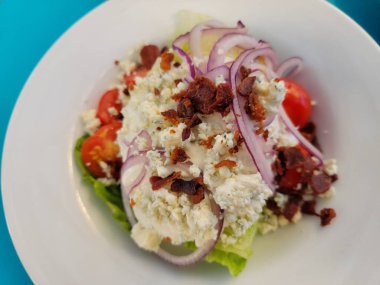 Salata, marul, domates, mavi peynir, pastırma ve soğan.