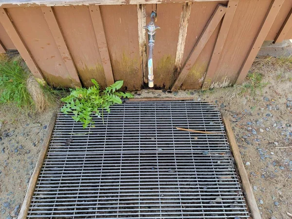 Wasserhahn Und Metallabfluss Oder Gitter Mit Unkraut Und Gebäude — Stockfoto