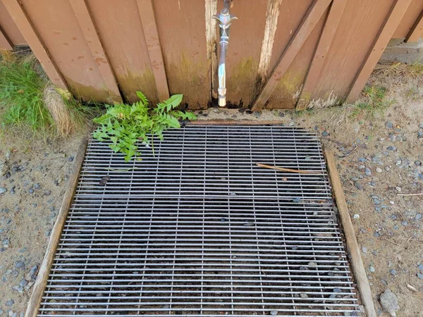 Wasserhahn Und Metallabfluss Oder Gitter Mit Unkraut Und Gebäude — Stockfoto