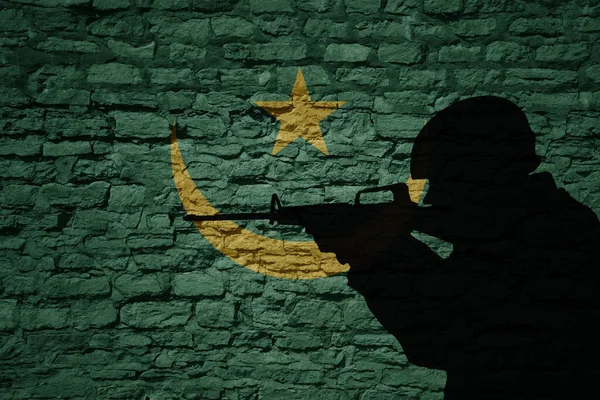 モーリタニアの国旗のある古いレンガの壁に兵士のシルエット 軍事力 — ストック写真