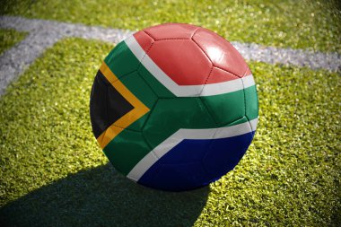 Futbol topu ile Güney Afrika ulusal bayrak beyaz satırı yakınlarında yeşil alan üzerinde yatıyor