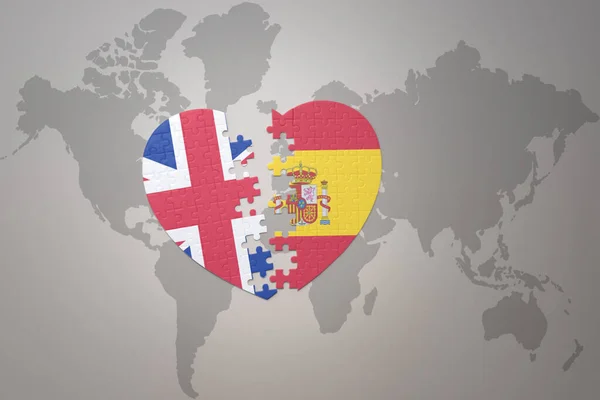 Serce Puzzle Flagą Narodową Hiszpanii Wielkiej Brytanii Tle Mapy Świata — Zdjęcie stockowe