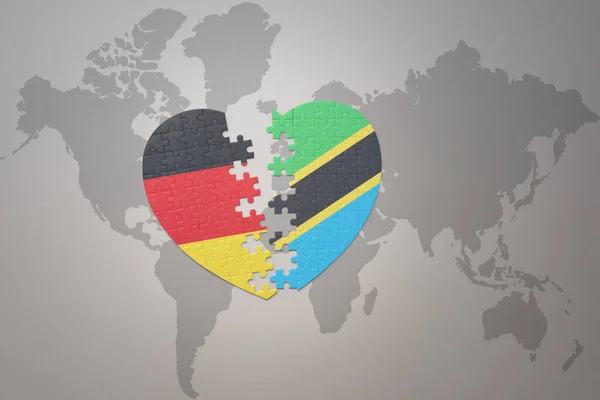 Puzzle Srdce Národní Vlajkou Tanzanie Německo Pozadí Mapy Světa Koncept — Stock fotografie