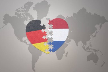 Bir dünya haritasında Hollanda ve Almanya 'nın ulusal bayrağını taşıyan bir bulmaca kalbi. Kavram. 3B illüstrasyon