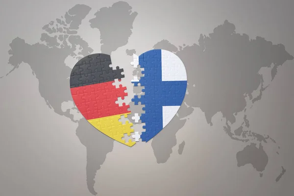フィンランドとドイツの国旗が描かれたパズルハートが世界地図の背景にあります コンセプト 3Dイラスト — ストック写真