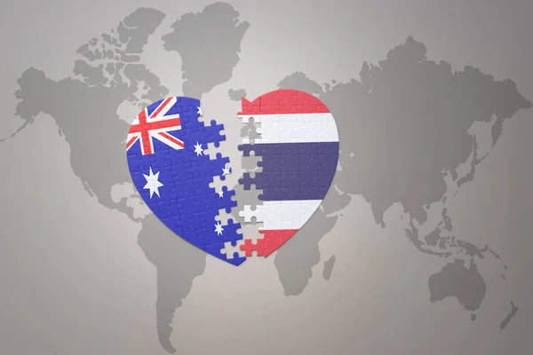 パズルハートで世界地図の背景にタイとオーストラリアの国旗が描かれています コンセプト 3Dイラスト — ストック写真
