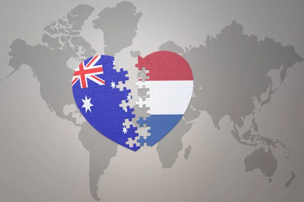 パズルハートで世界地図の背景にオランダとオーストラリアの国旗が描かれています コンセプト 3Dイラスト — ストック写真