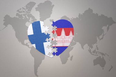 Kamboçya ve Finlandiya 'nın ulusal bayrağını taşıyan bir yapboz kalbi dünya haritasının arka planında. Kavram. 3B illüstrasyon