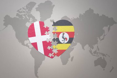 Uganda 'nın ulusal bayrağı ve Danimarka' nın yapboz kalbi dünya haritasının arka planında. Kavram. 3B illüstrasyon