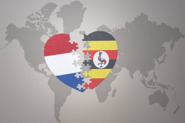 Uganda ve Hollanda 'nın ulusal bayrağıyla bir dünya haritasında bulmaca kalbi. 3B illüstrasyon