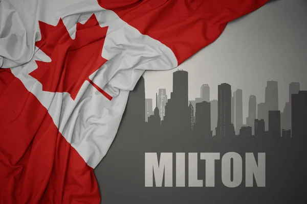 カナダのカラフルな国旗を灰色の背景に振っているミルトンのテキストがある街の抽象的なシルエット — ストック写真