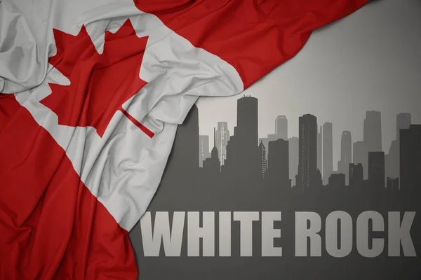 灰色の背景にカナダのカラフルな国旗を振って近くのテキストホワイトロックと街の抽象的なシルエット — ストック写真